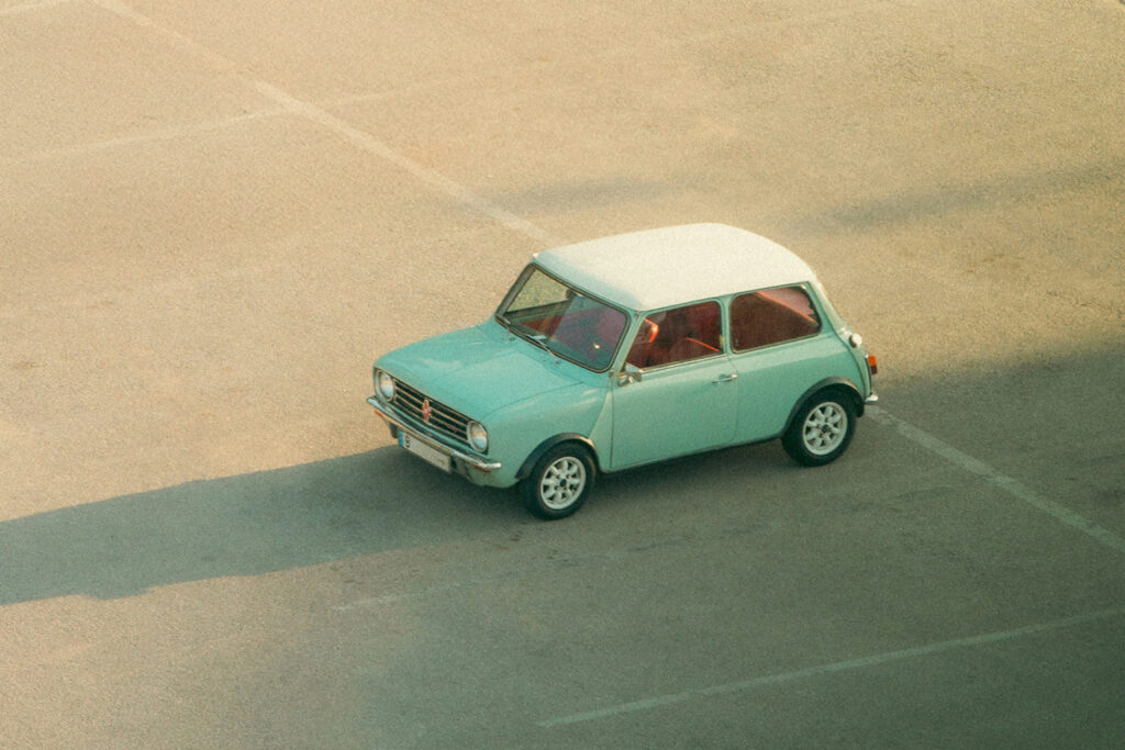 Parker Mini Cooper in einem leeren Parkplatz bei Sonnenuntergang
